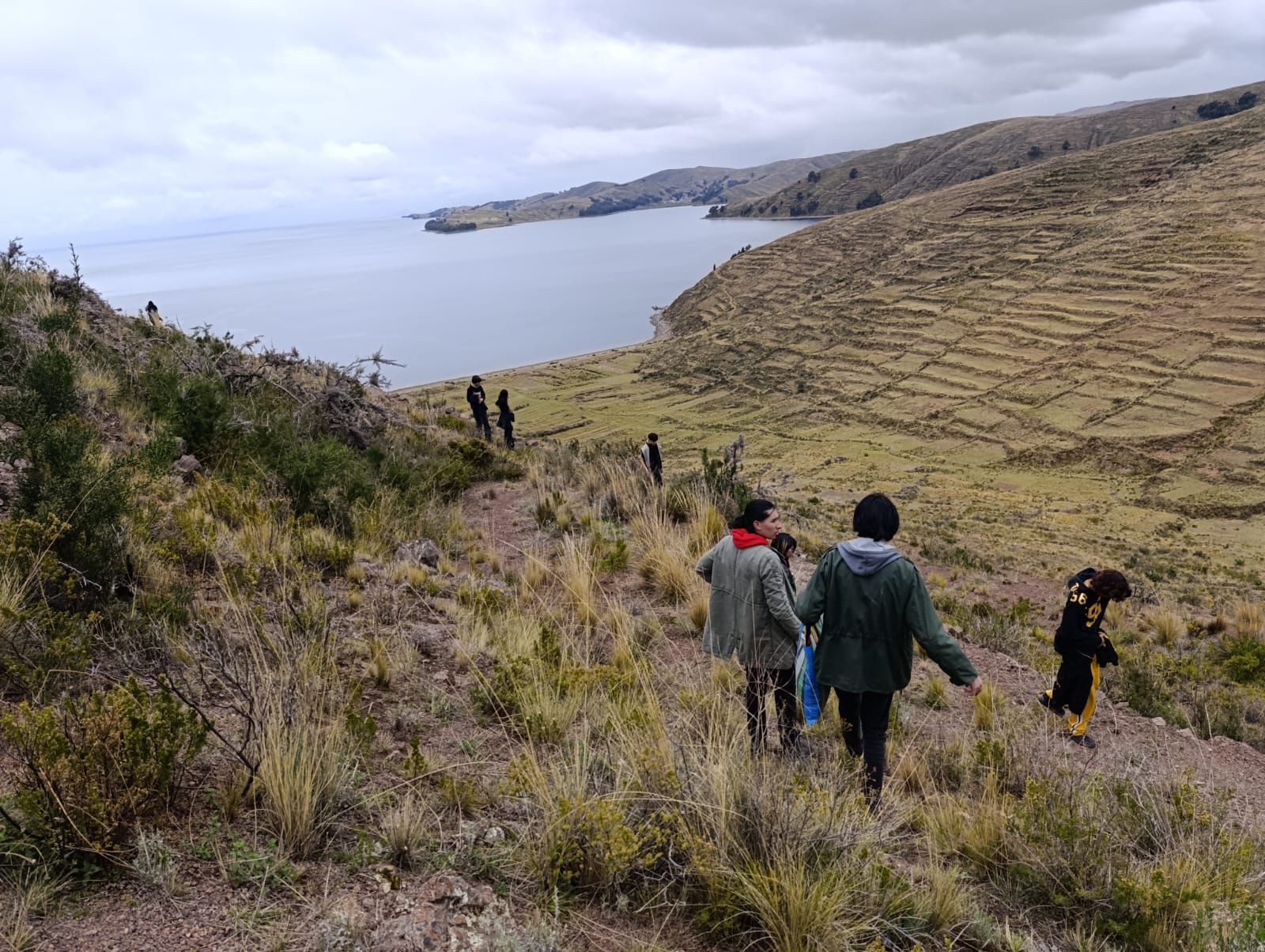 Caminantes bajando por una colina hacia el lago